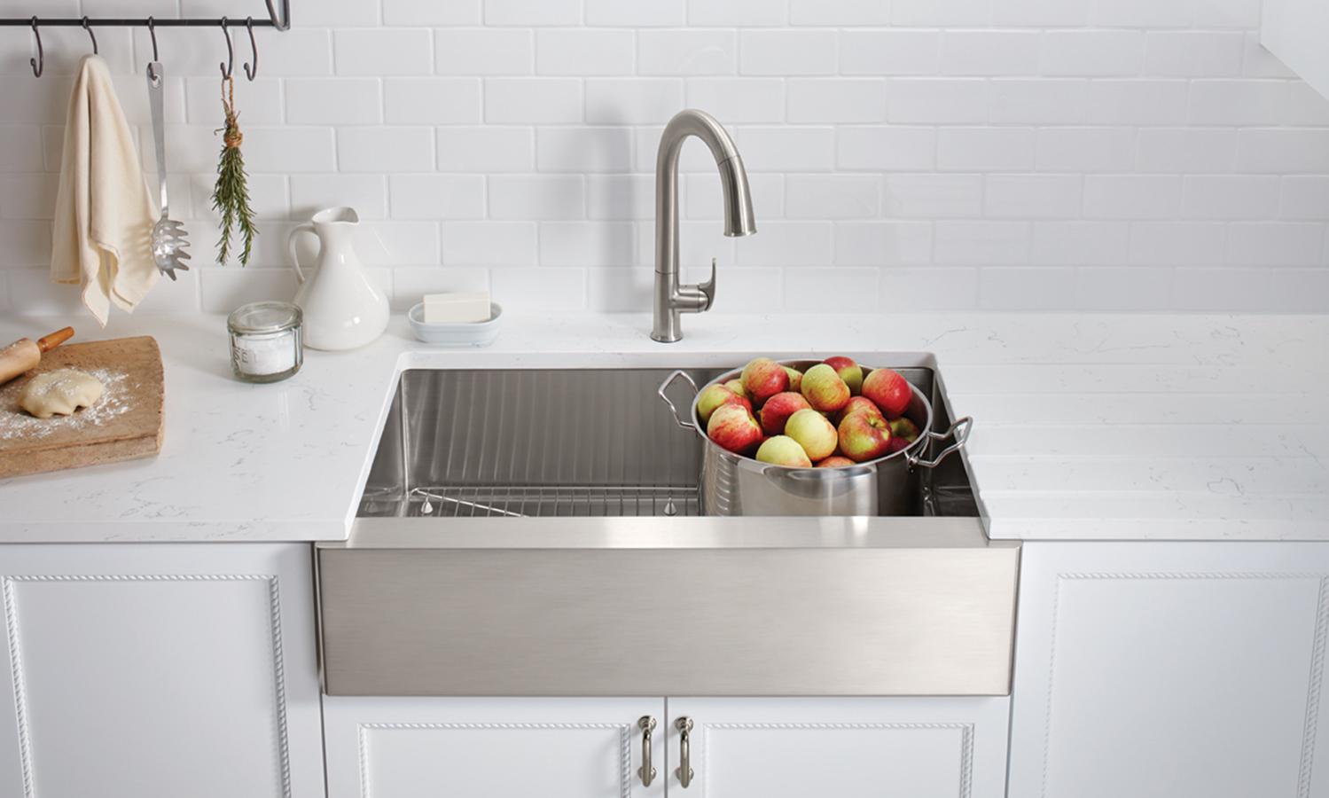 stainless steel under-mount sink, and a faucet, on a white countertop